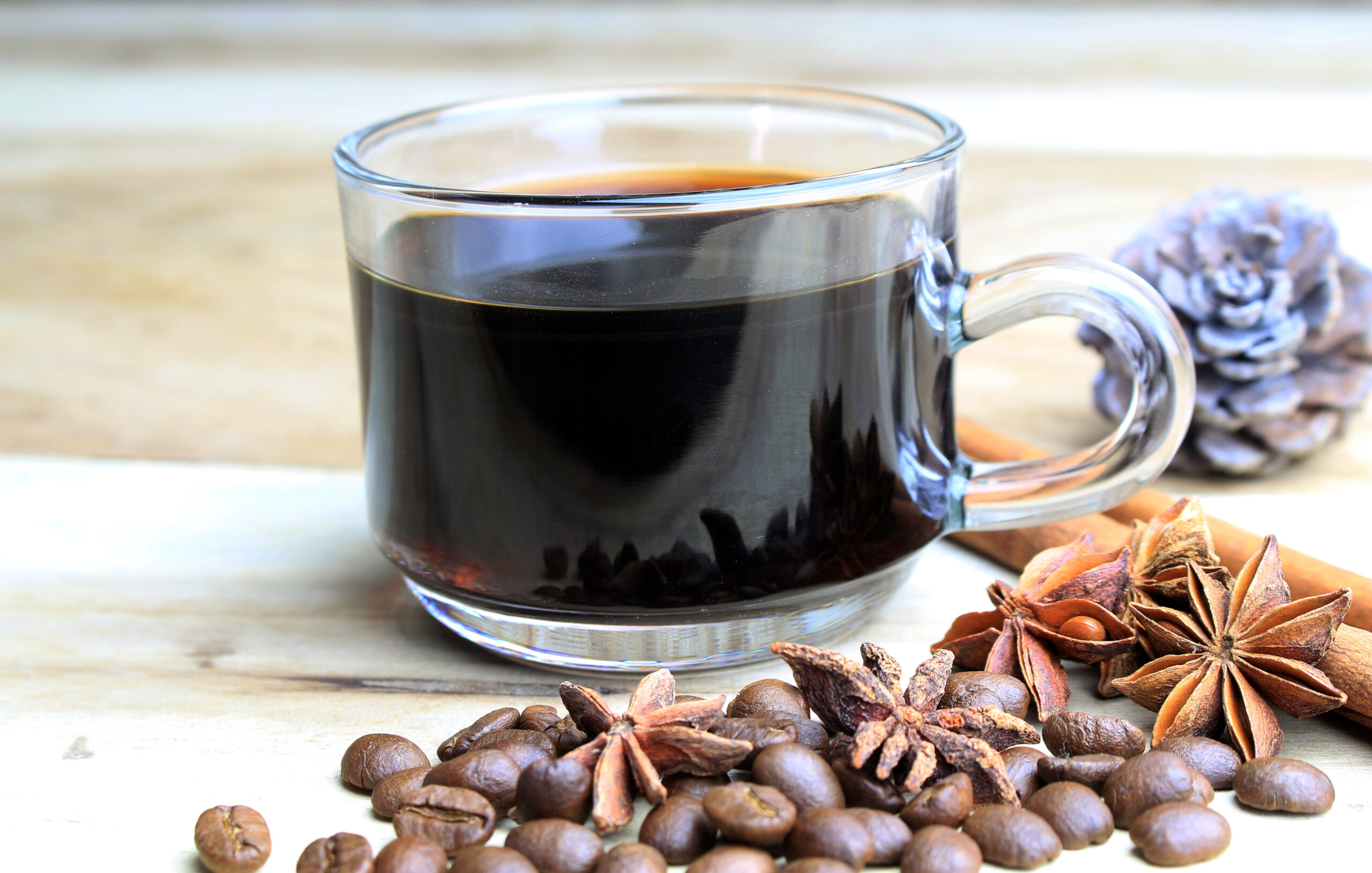 cup of coffie with cinnamon and star anise on wooden background